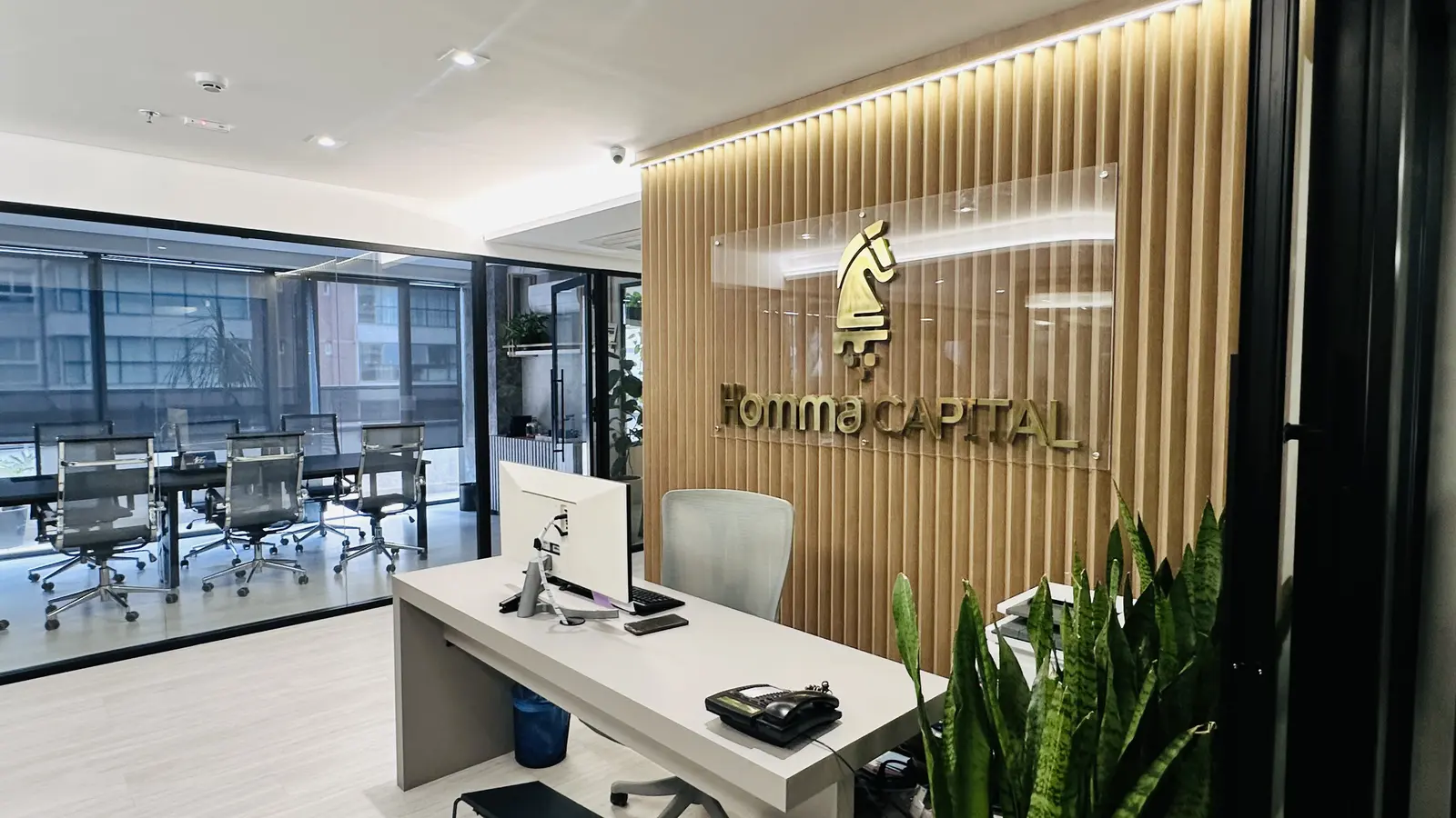 Recepção da Homma Capital com sala de reunião ao fundo