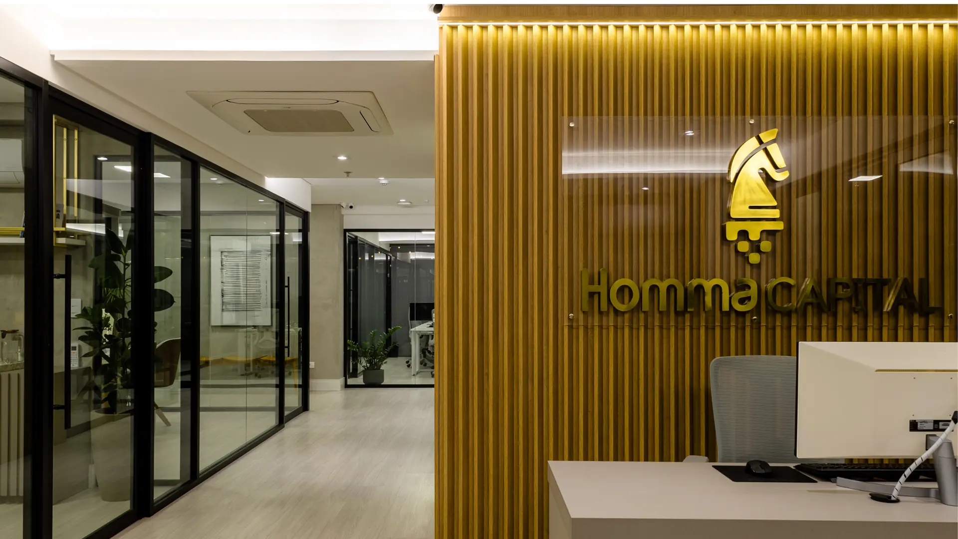 Recepção da sede da Homma Capital com ambientes de trabalho ao fundo