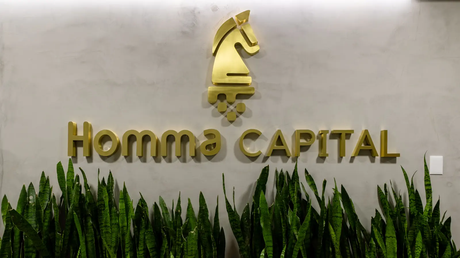 Logotipo da Homma Capital na área interna da sede da empresa